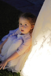 Bambina affianco al vestito della sposa illuminato
